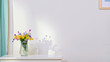 Bouquet of colorful flowers in a vase on white table in interior room. Empty space for text. White wall background