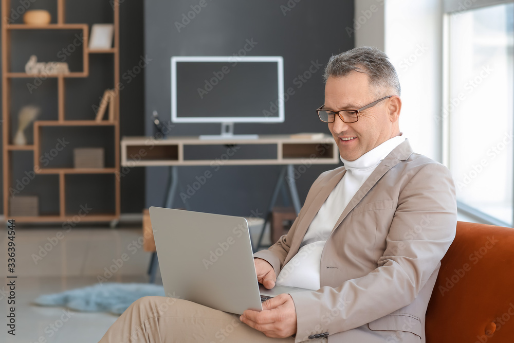 Mature man using laptop at home