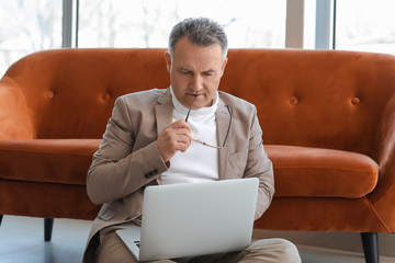 Canvas Print - Mature man using laptop at home