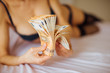 © Alina Rosanova - Beautiful undressed woman lying on the bed with a lot of money in her hands