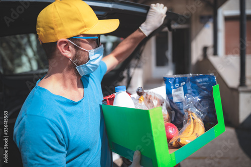 Fotomural Delivery guy with protective mask and gloves delovering groceries during lockdown and pandemic