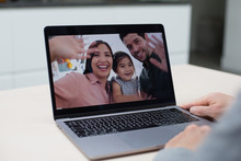 Family Using Video Call At Home To Connect With Family At Home In Kitchen