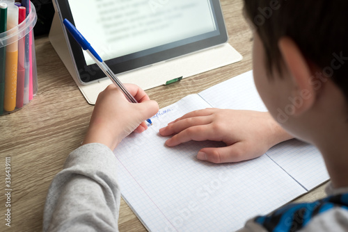 Fotografía Close-up boy studying at home with tablet and doing school homework