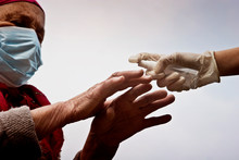An Old Grandmother In A Medical Mask Disinfects Her Hands To Prevent Infection With A Coronavirus Infection. Old Hands Disinfector Closeup. Quarantine Measures And Coronavirus.