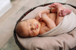 © Olga Gordeeva - Newborn baby boy, in the photo the baby is 7 days old from birth, wrapped in a wrapping, sleeps sweetly in a basket