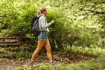 Wall Mural - young blond hair woman hiking in nature.