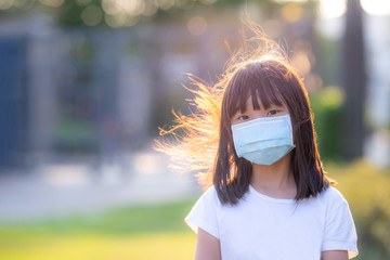 Asian little girl wearing a mask protection corona virus 2019-nCoV (COVID-19) and as dust mask protect for PM2.5,Copy space for writing articles,Insurance for your health concept.