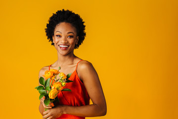 Wall Mural - Portrait of a happy smiling young woman in orange with  yellow peony flowers bouquet