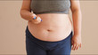 Overweight woman applying diabetes medicine injection into her stomach