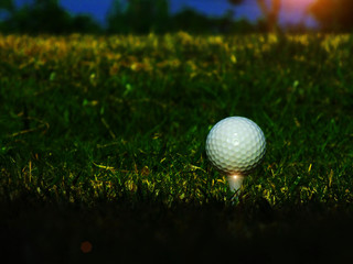 Golf ball, white ball on the tee, for athletes to start the match on the green grass background. And the sky is beautiful