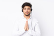 © luismolinero - Telemarketer Arabian man working with a headset isolated on white background pleading