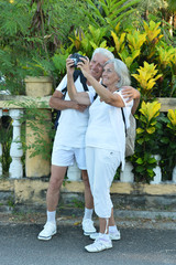 Canvas Print - Elderly couple of tourists with camera. Travel