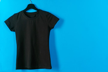 Poster - Black plain t-shirt hanging on a hanger, copy space