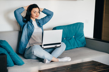 Remote work. Young woman learning from home online using laptop and headphones. Distance learning, isolation, freelance business.