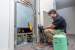 © spatesphoto - HVAC worker checking refrigerant
