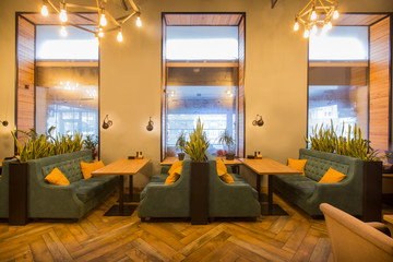 Restaurant in modern style, light colors interior with green sofas