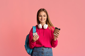 Wall Mural - Girl with headphones, smartphone and coffee in her hands