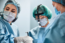 A Surgeon S Team In Uniform Performs An Operation On A Patient In The Clinic Of The Center.
