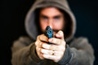 © Federico - Criminal with a hand gun aiming to the camera, blurred background.