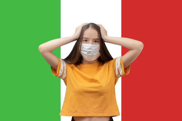 Wall Mural - Danger and panic due to coronavirus in Italy. Young girl in antibacterial medical mask holds her head, scared on the background of the flag