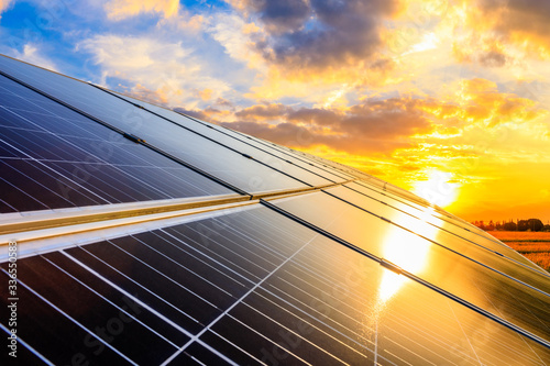 Fototapeta na szkło Photovoltaic panel słoneczny na zmierzchu nieba tle, zielony czystej energii pojęcie.