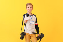 Little Journalist With Microphone And Camera On Color Background
