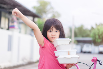 Wall Mural - Delivery service,Takeaway, Food delivery and Stay at home safe lives from Covid19 Coronavirus.Little asian girl holding go box food with hungry.Delivering Food In City.Delivery food service from home.