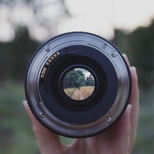 Close-up Of Hand Holding Camera Lens