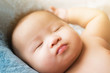 © Ann Patchanan - top view Portrait of a newborn Asian cute baby boy wore blue Infant bodysuit on the bed , Charming Fat baby 5 month old lies in bed with a doll,enjoy and happy