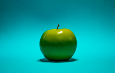 green apple on light blue background