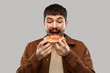 © Syda Productions - fast food and people concept - hungry young man eating pizza over grey background