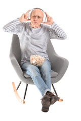 Poster - Portrait of elderly man listening to music on white background