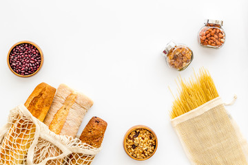 Wall Mural - Eco bag, glass jars on white background, top view. Zero waste food storage concept copy space