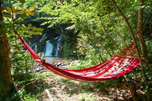 View Of Empty Hammock Between Trees Waterfall On Background