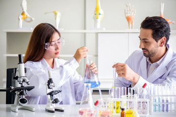 Wall Mural - attractive happiness scientist lab technician assistant analyzing sample in test tube at laboratory.