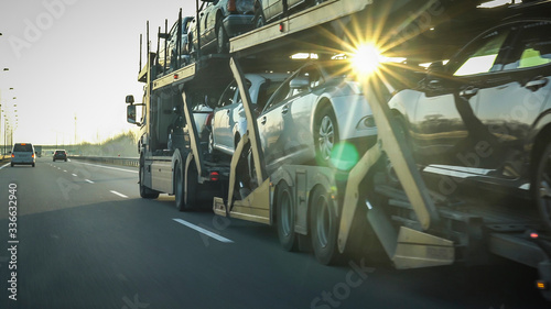 Fotomural Car transporter trailer loaded with many cars on a highway, motion blur effect