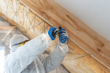 Wall Mural - Foreman in overalls working with rockwool insulation material