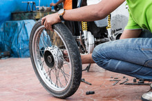 Thai Yiung Man Is Holding Motorcycle Wheel To Repair After Tire Leaks Or Disc Damage. Motorcycle Repair