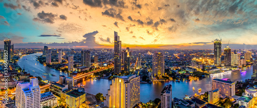 Fotografía Aerial view Bangkok City skyline and skyscraper on Sathorn Road business and financial in Bangkok downtown, Panorama of Taksin Bridge over Chao Phraya River, Bangkok, Thailand at sunset