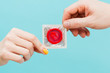 People holding a red condom