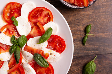 Wall Mural - Italian Caprese dish with mozzarella cheese, fresh tomatoes, basil and extra virgin olive oil. Italian food, ideas for fast lunch, summer lunch.