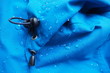 Closeup of water drops on bright blue fabric and elastic band with waterproof design to protect fabric of the cloth from humidity and to offer easy cleaning to users Fabric texture with design concept