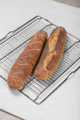 two wheat homemade baguettes on a light background. Craft and twine