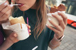 A woman with an appetite eats a traditional Czech sweet pastry called Trdelnik or Trdlo in Prague street