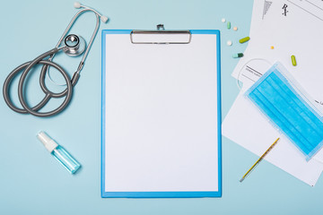 medical equipment mockup clipboard with stethoscope and drug, surgical mask on blue copy space background.