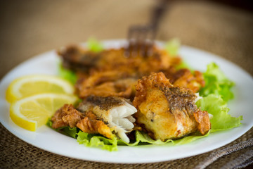 Wall Mural - fried hake fish in batter with lettuce and lemon in a plate