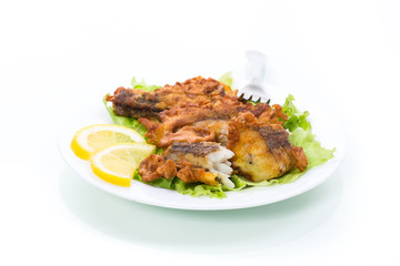 Wall Mural - fried hake fish in batter with lettuce and lemon in a plate