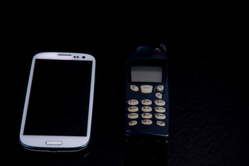 Three mobile phone generations side by side from old to smartphone