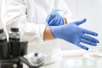 Medical worker wearing protective gloves in laboratory. Protecting healthcare workers from infection.