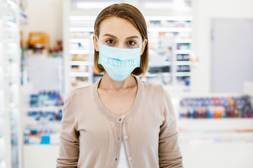 Wall Mural - Young adult woman in a protective mask